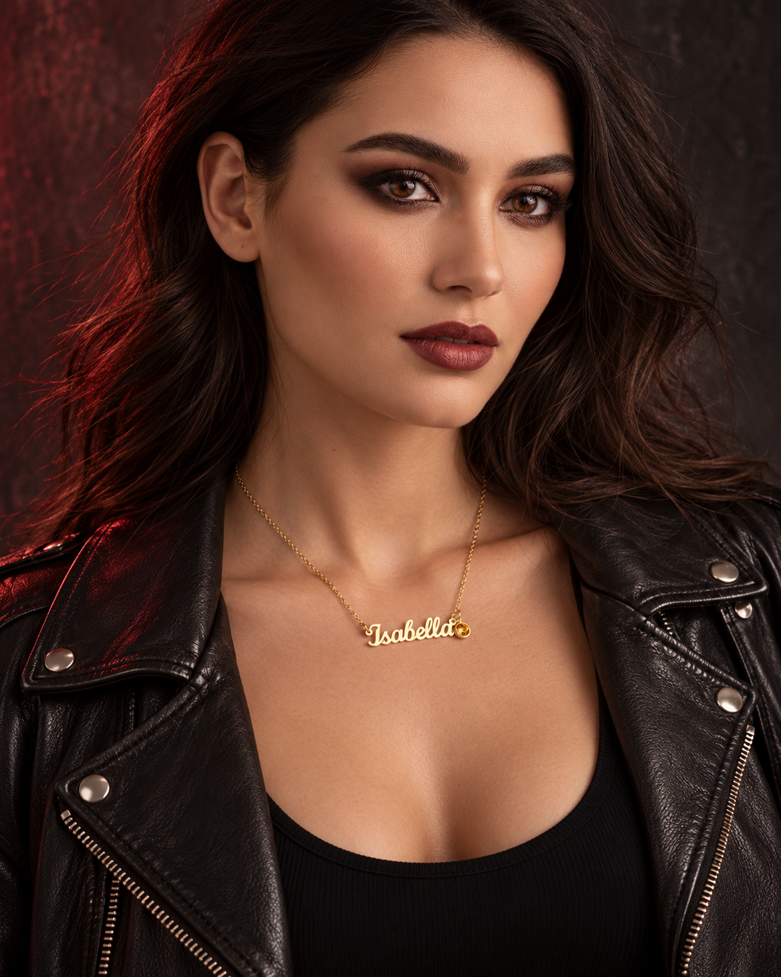 Personalised gold Isabella name necklace with amber birthstone, styled with a black leather jacket