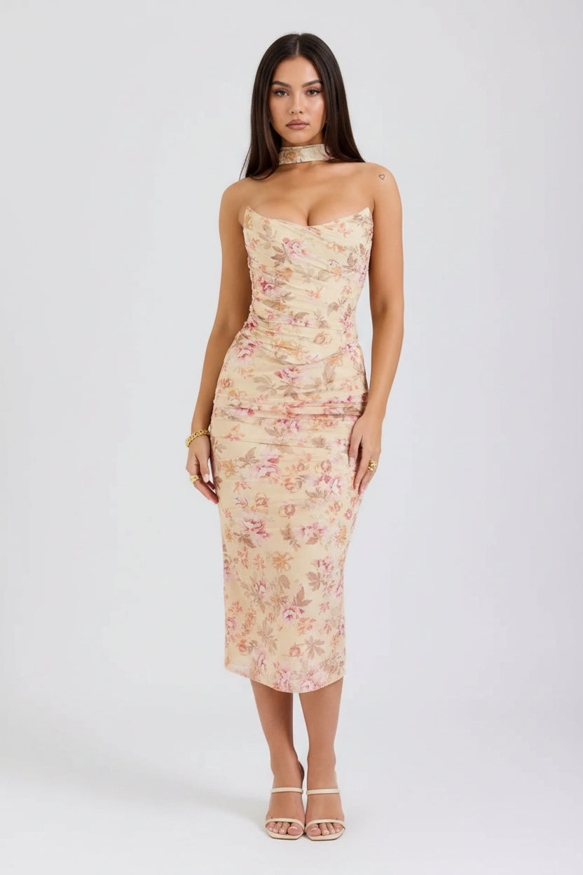 Woman wearing a strapless floral dress on a plain background