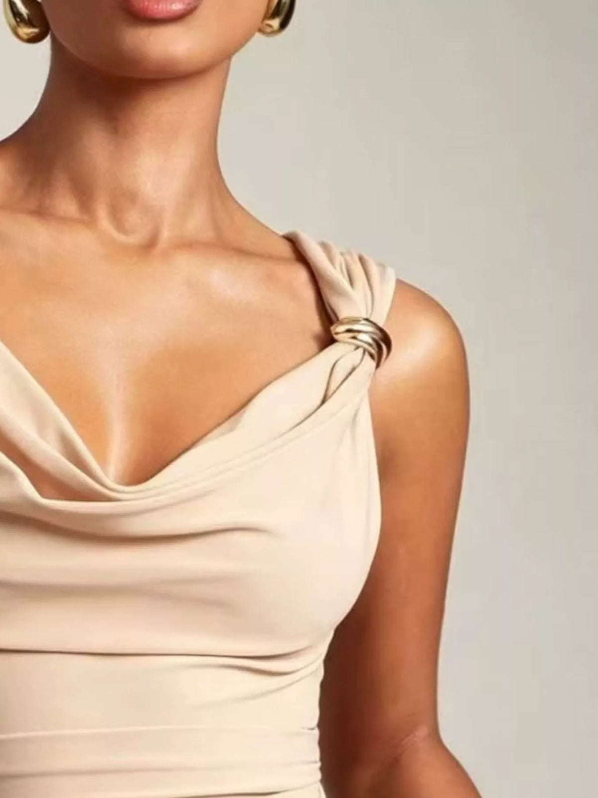 Beige sleeveless top worn by a person on a plain background