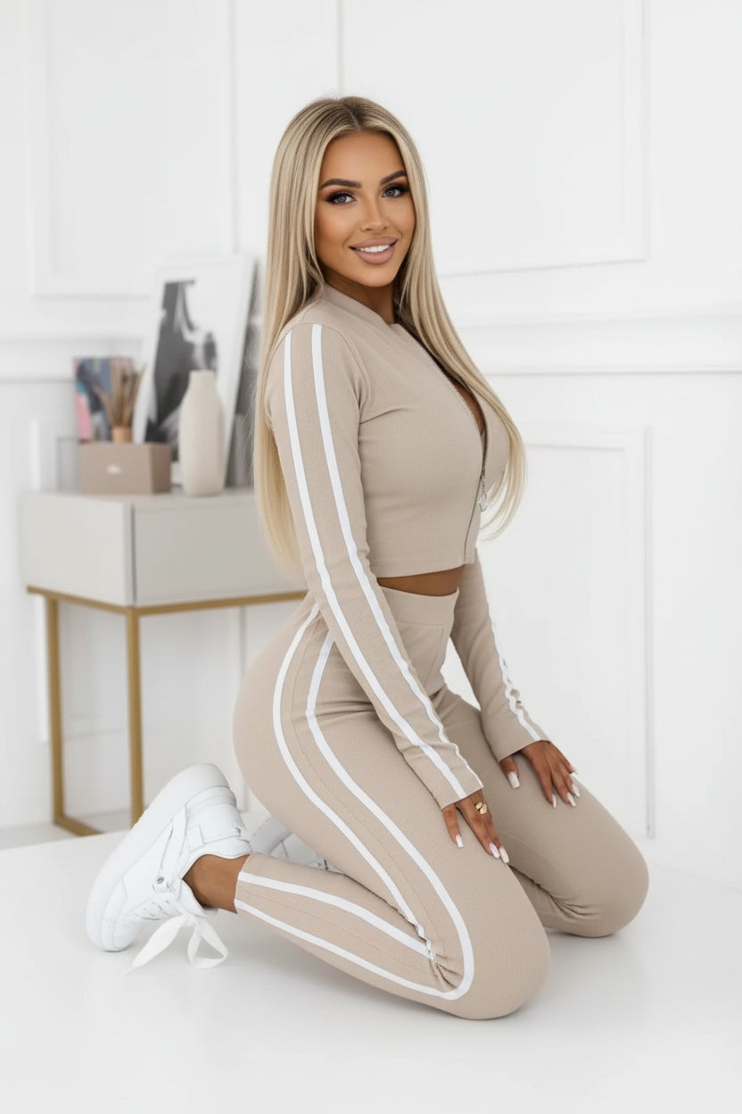 Person wearing a beige and white striped outfit in a minimalistic room.