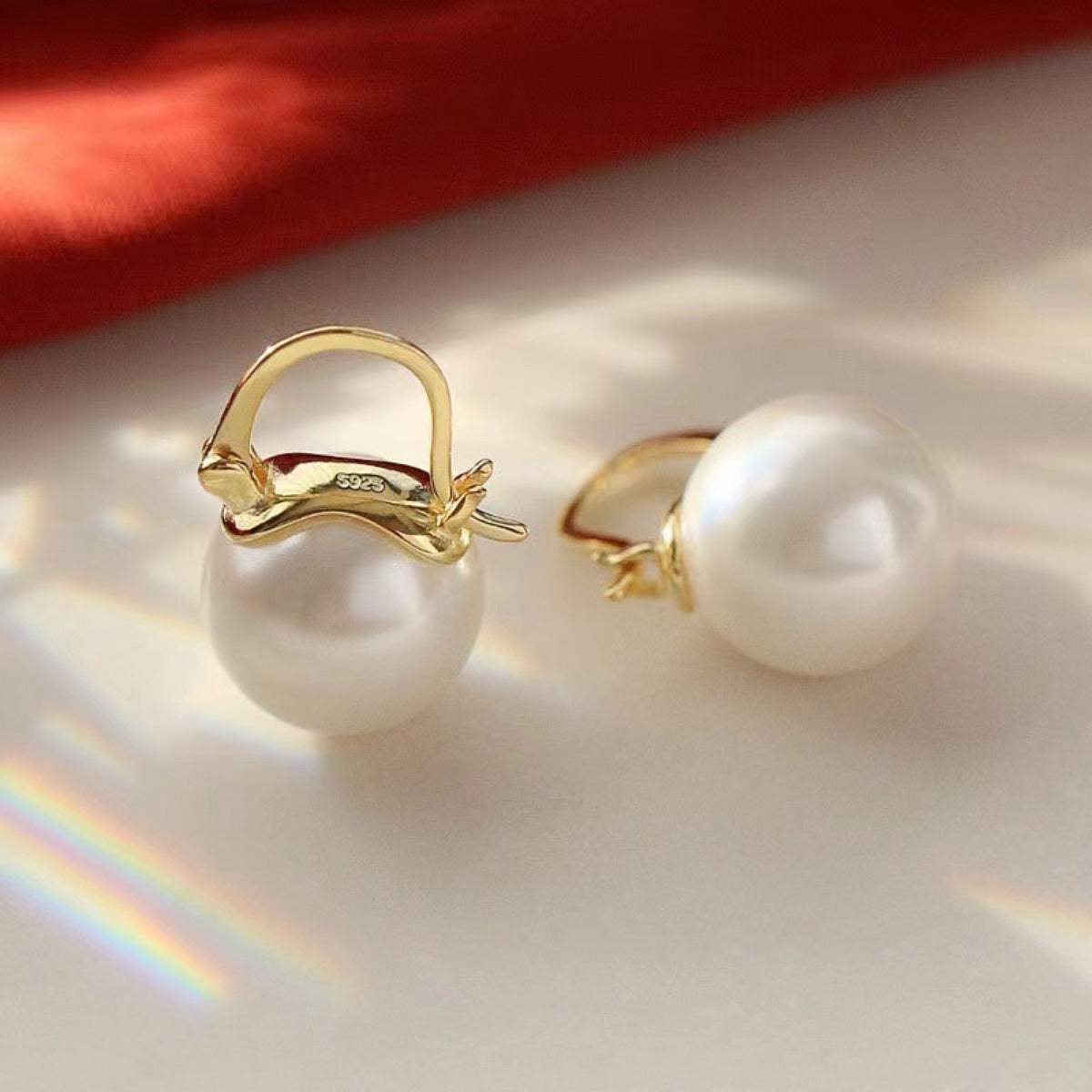 Close-up texture of polished 18K gold plating and lustrous synthetic pearl