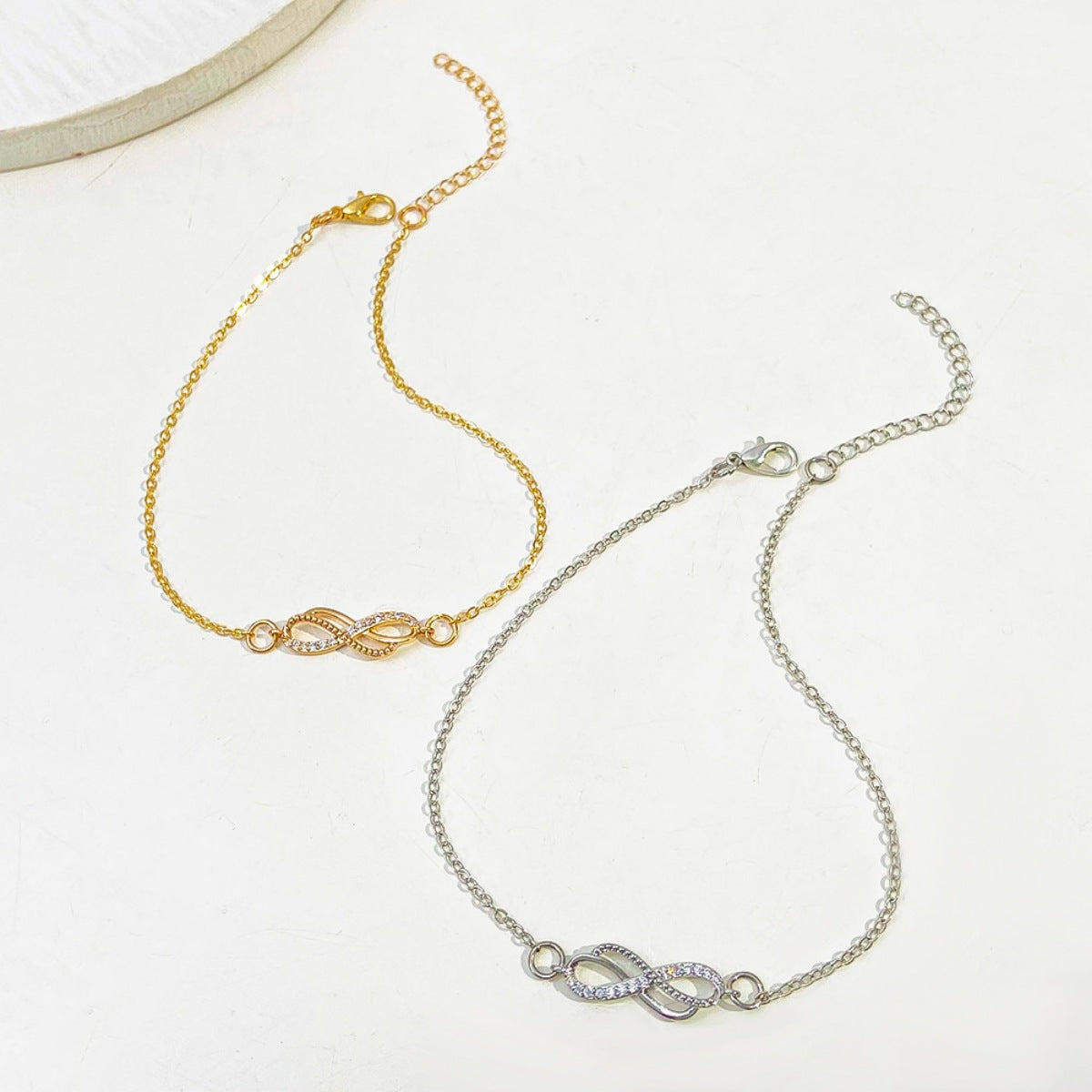 Detail shot of 18K gold-plated infinity knot and polished sterling silver base