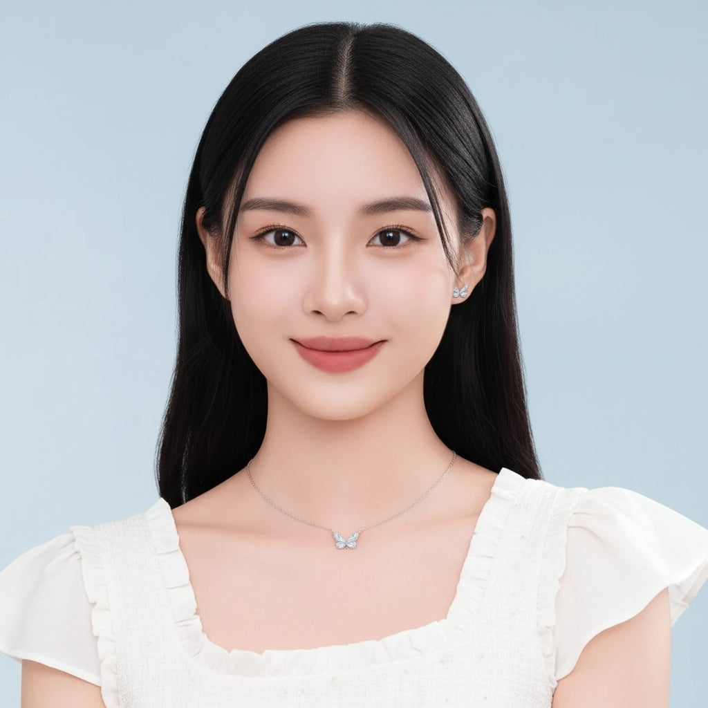Woman wearing a butterfly necklace and earrings against a light blue background
