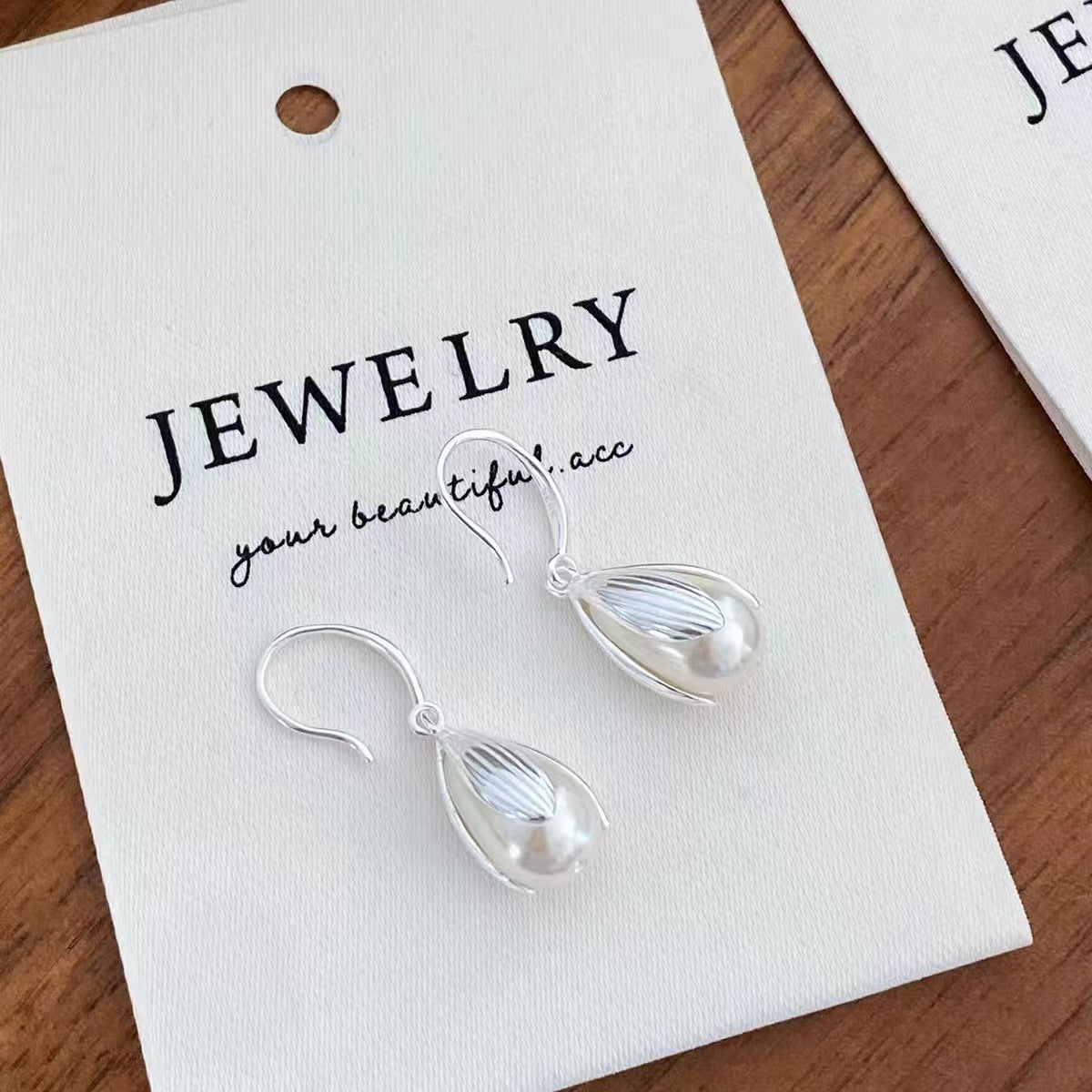 Flat lay of one-pair synthetic pearl drop earrings with matching luxury gift box
