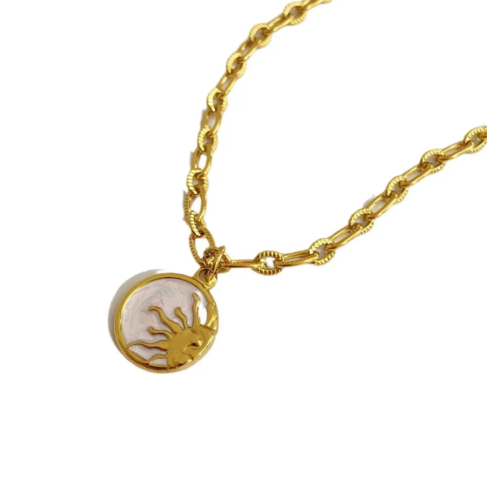Gold necklace with a round pendant on a white background