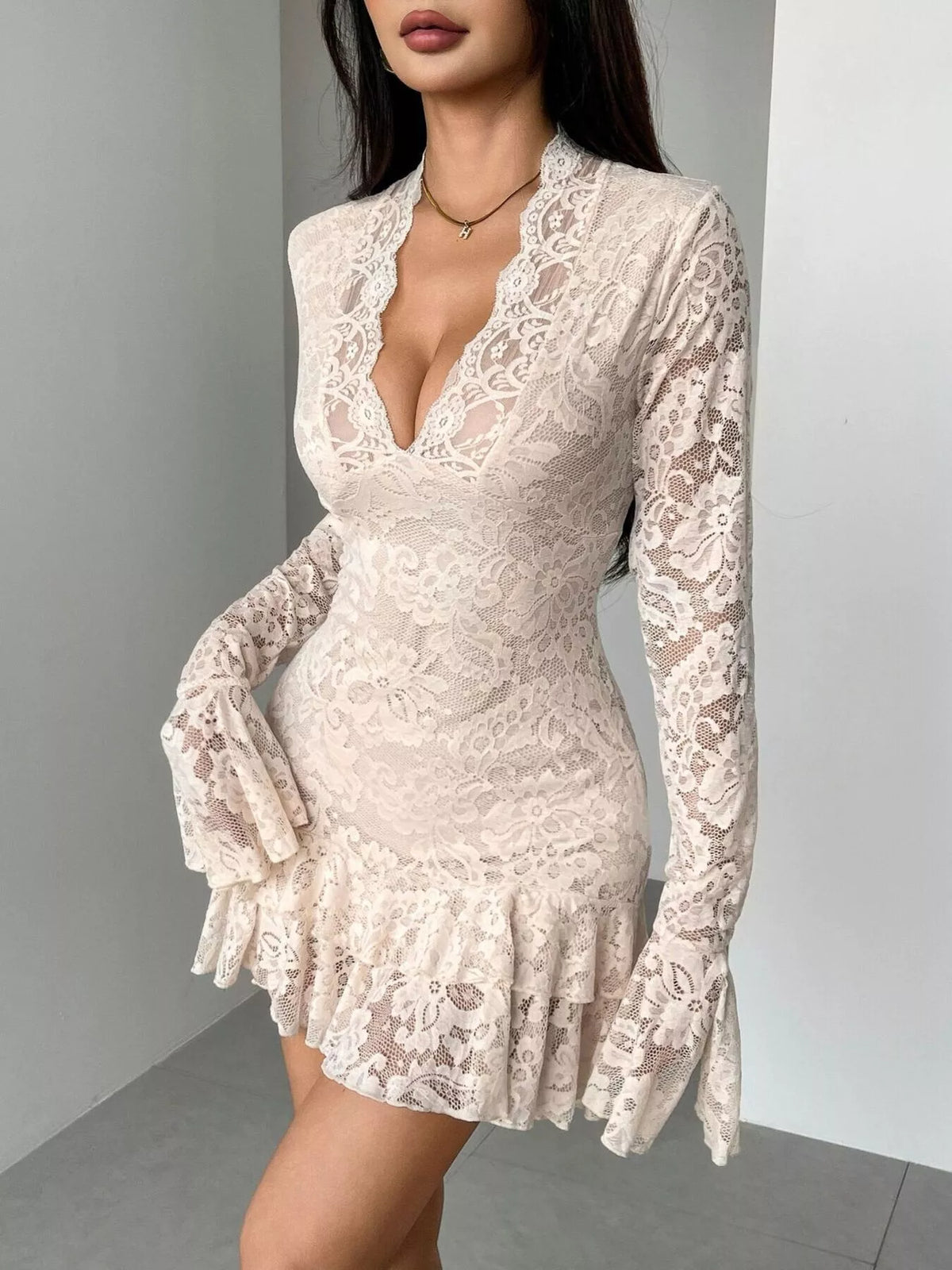 White lace dress with long sleeves on a plain background