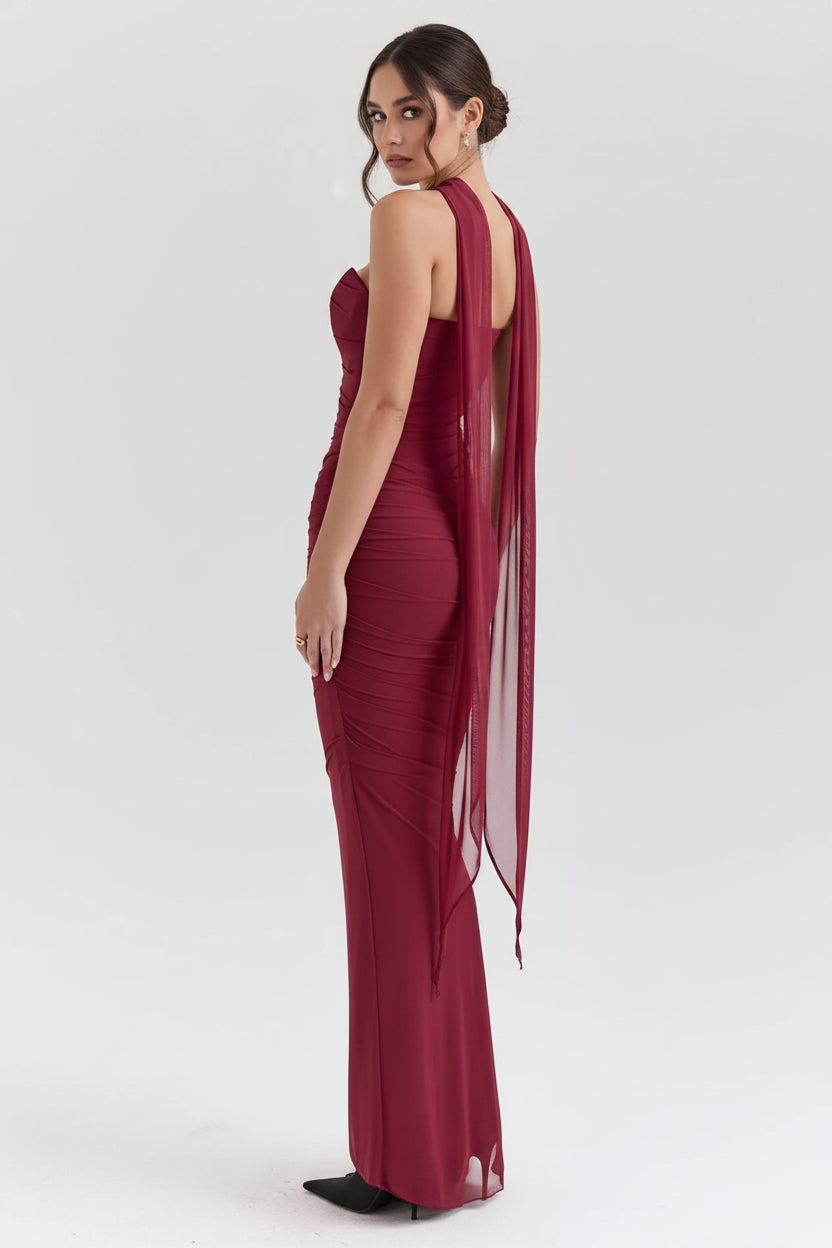 Red evening gown with a sheer overlay on a white background
