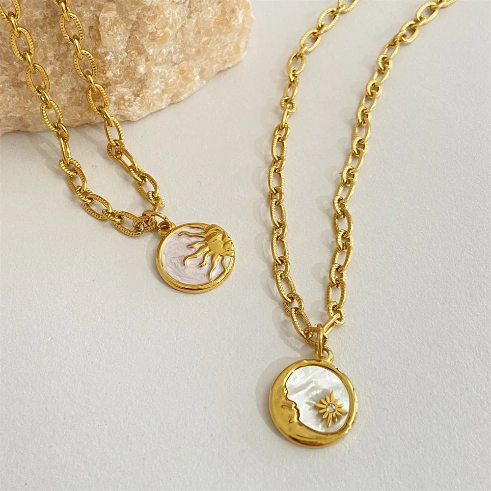 Two gold necklaces with circular pendants on a light background