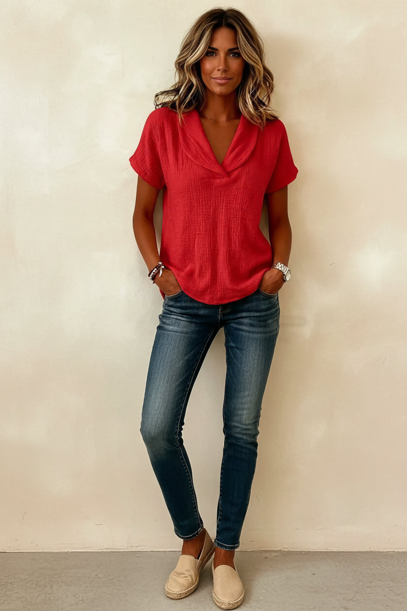 Person wearing a red short-sleeve top with a plain background