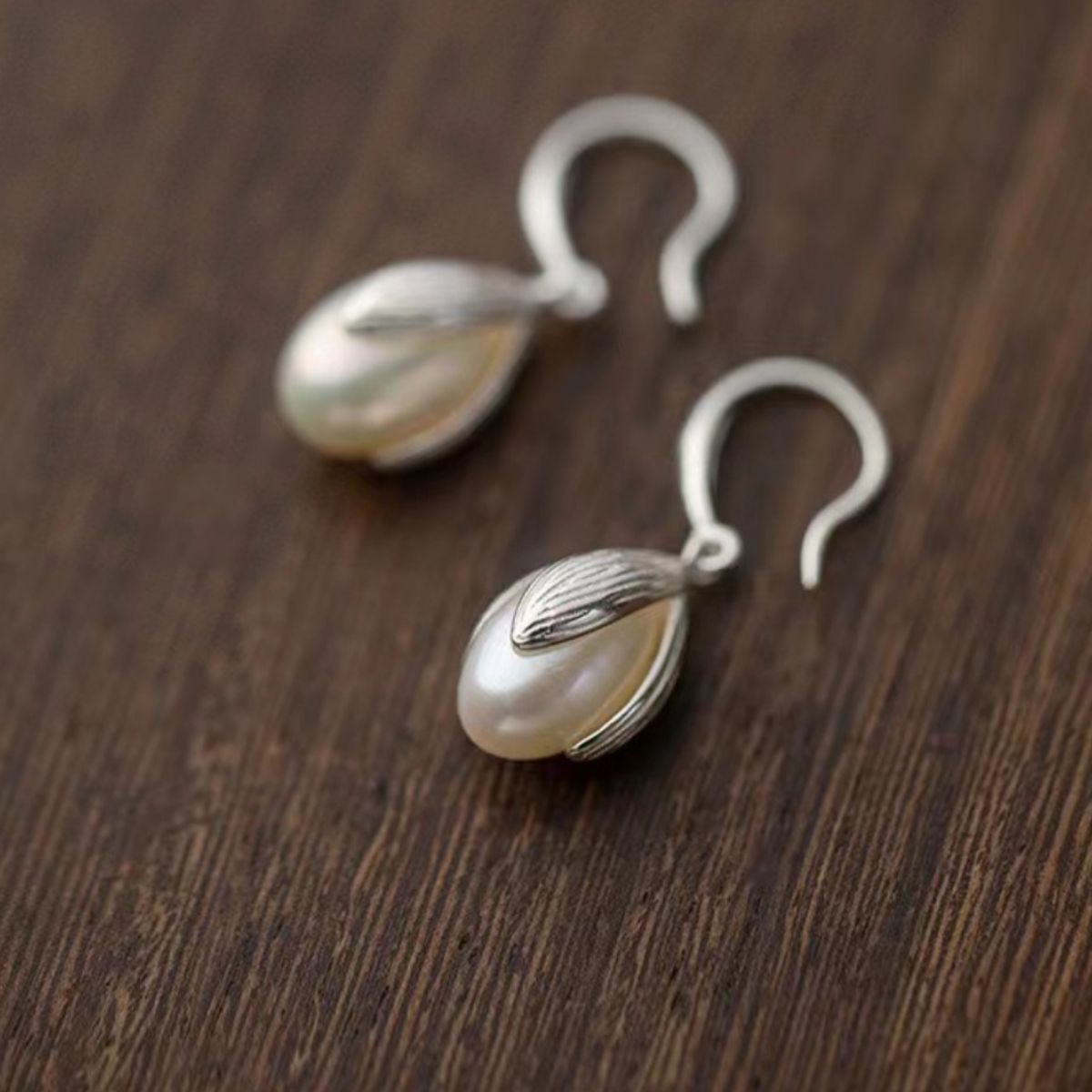 Pearl drop earrings styled with hoops and studs for a bold rebellious ear stack