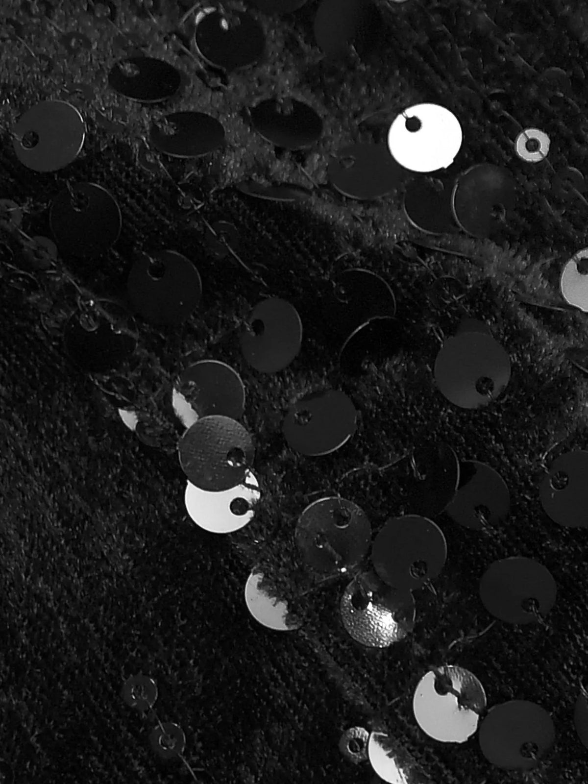 Close-up of black fabric with scattered silver sequins