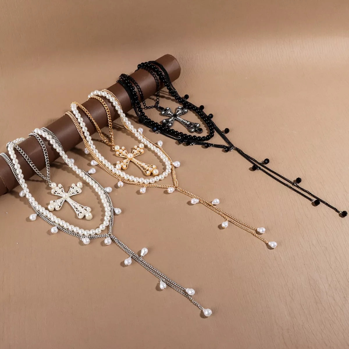 Set of necklaces with crosses and pearls on a brown background