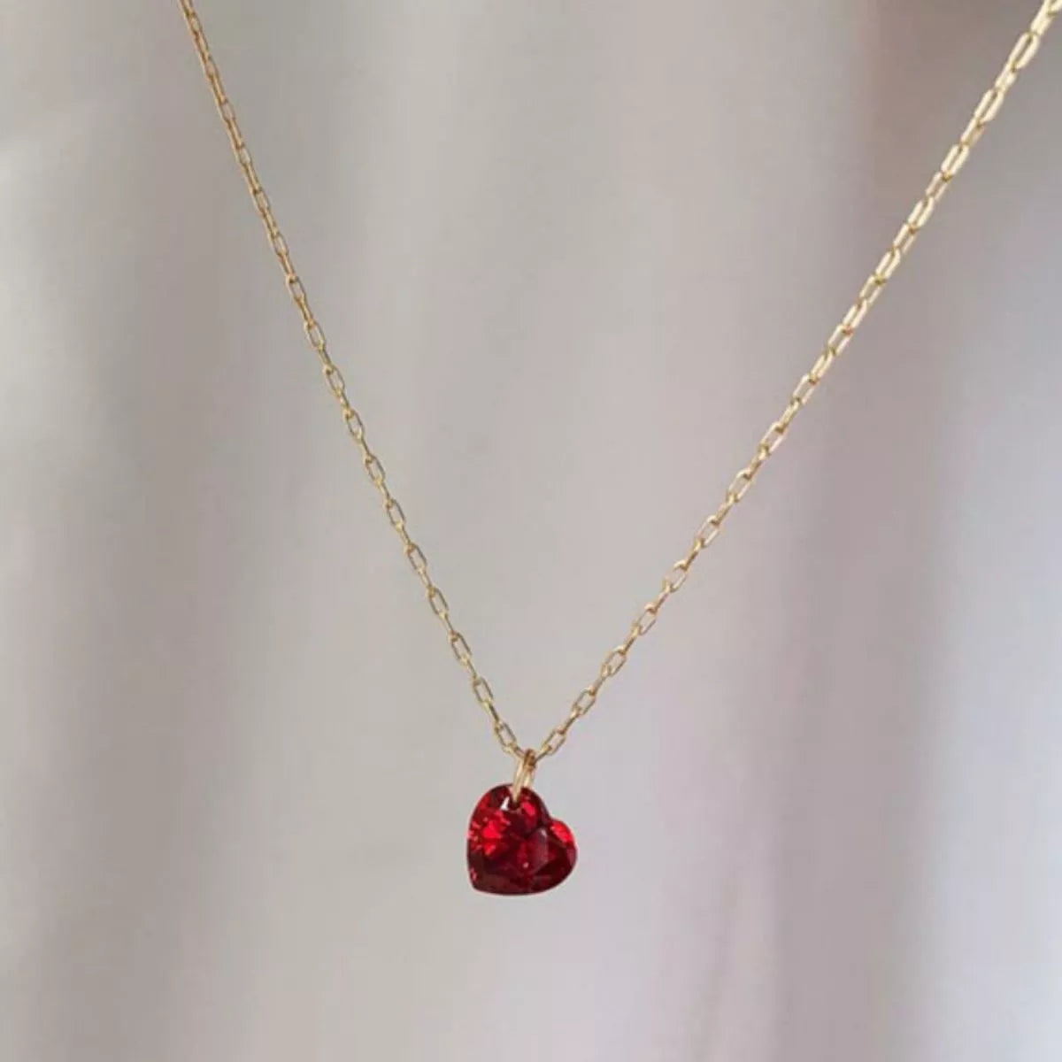 Rebellious Gal heart necklace with zircon stones layered with other chains on model