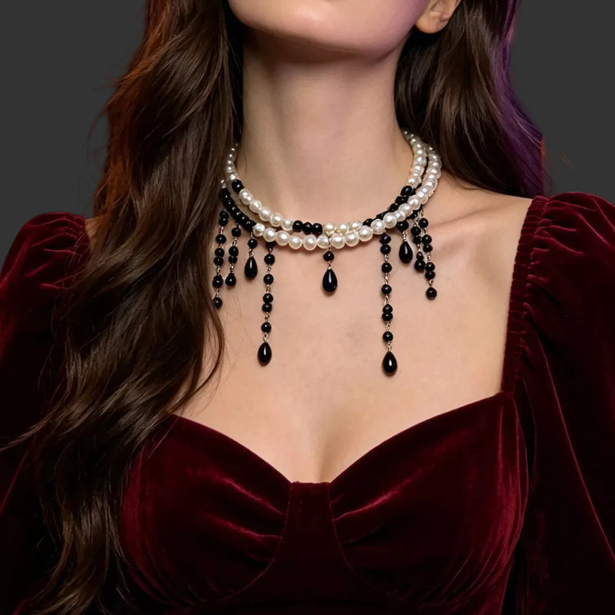 Pearl choker with black beaded drips worn with a burgundy velvet dress