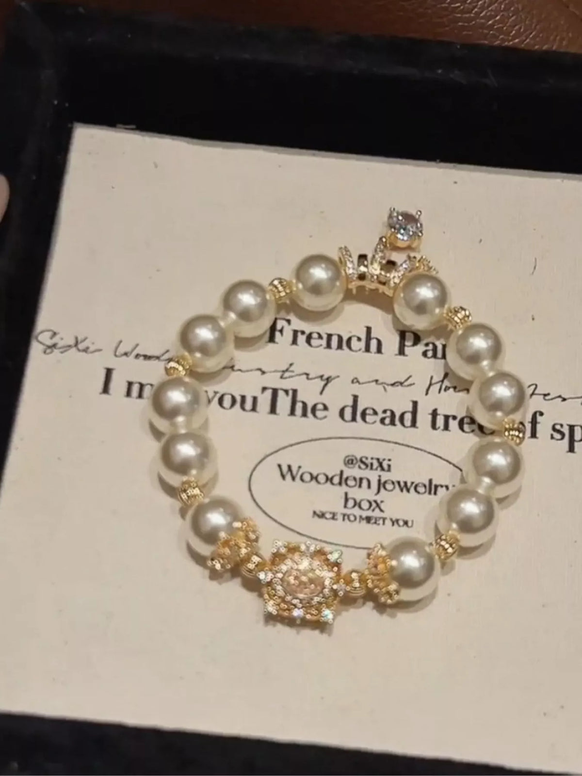 Pearl bracelet with gold accents on a card with text