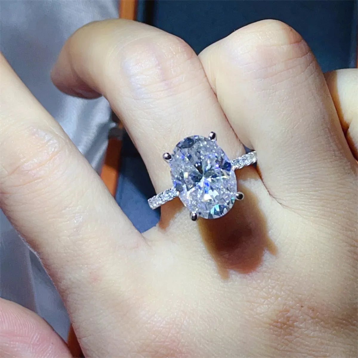 Woman wearing 8ct moissanite statement ring between fingers lifestyle