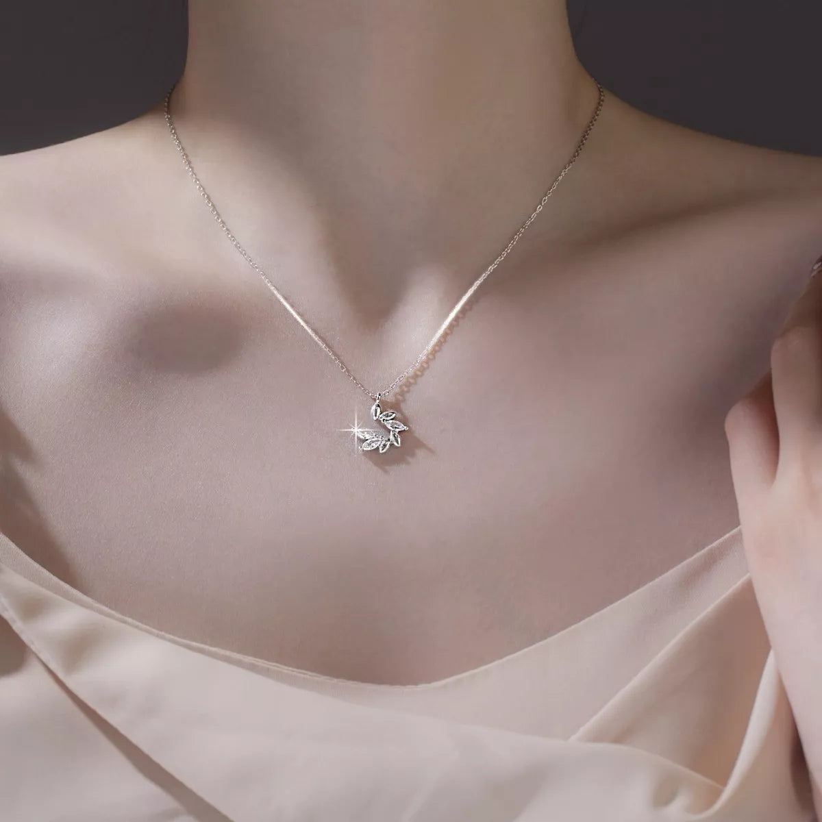 Necklace with a butterfly pendant on a person wearing a light pink top.