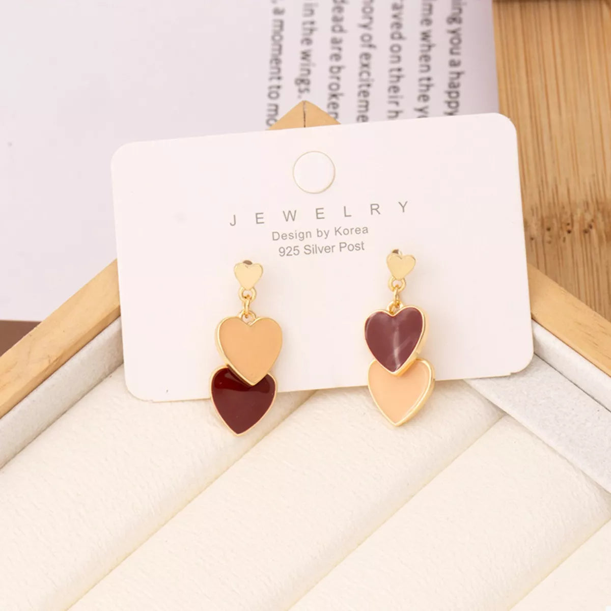Close-up double heart dangle earrings with resin detail and 18K gold plating