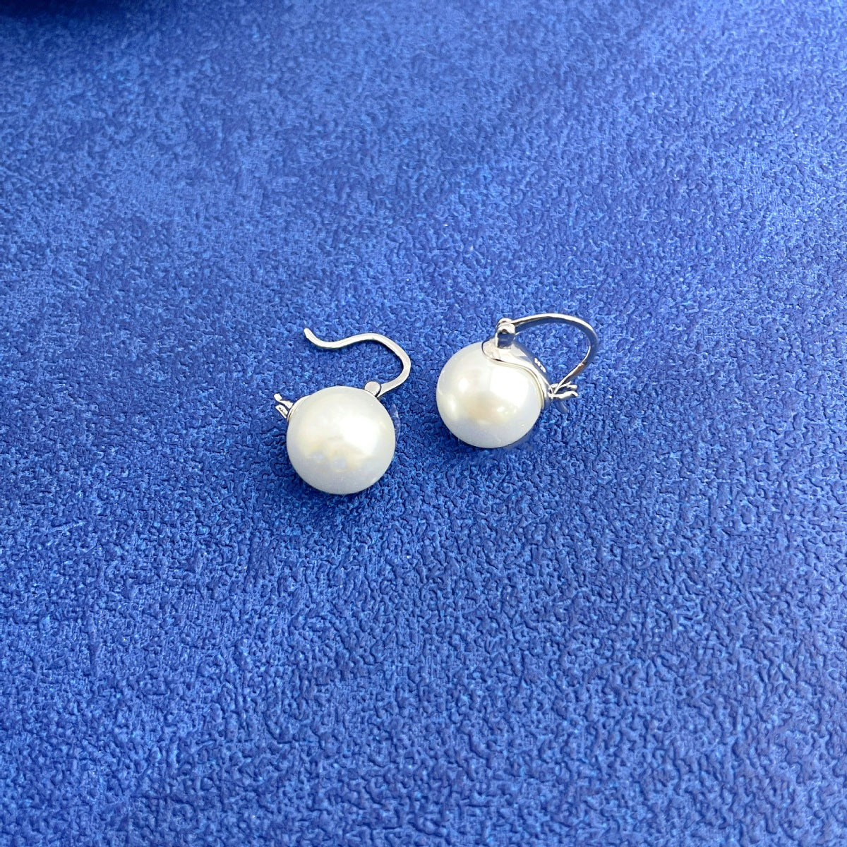 Flat lay of one-pair 18K gold-plated pearl earrings with matching luxury gift box