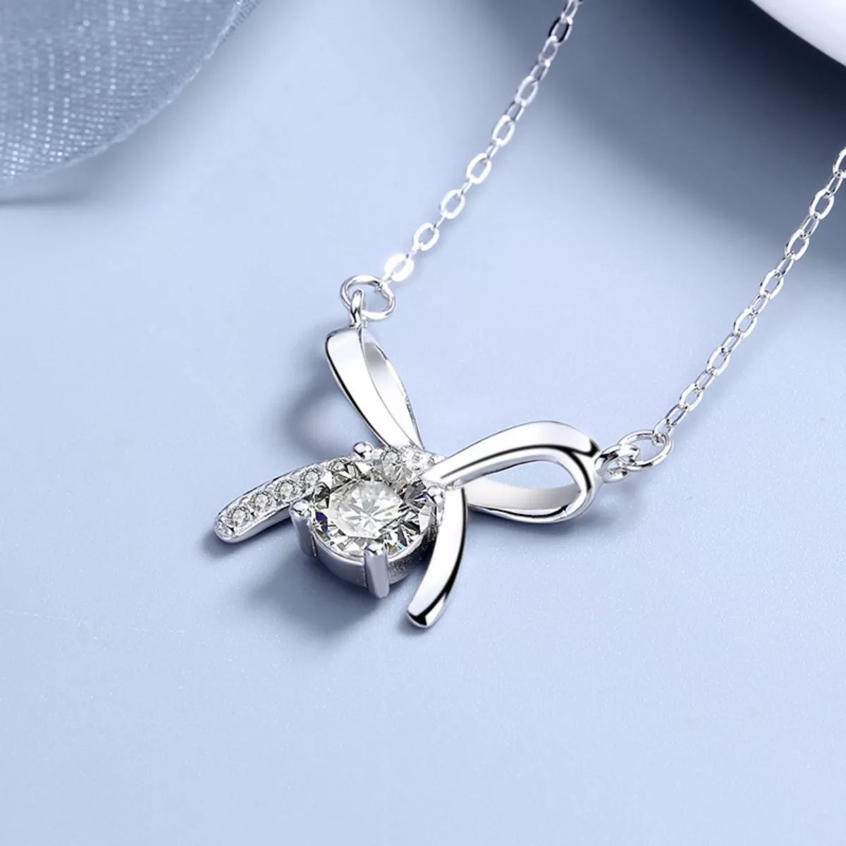 Detail shot of flowing ribbon design and zircon accents in platinum plating