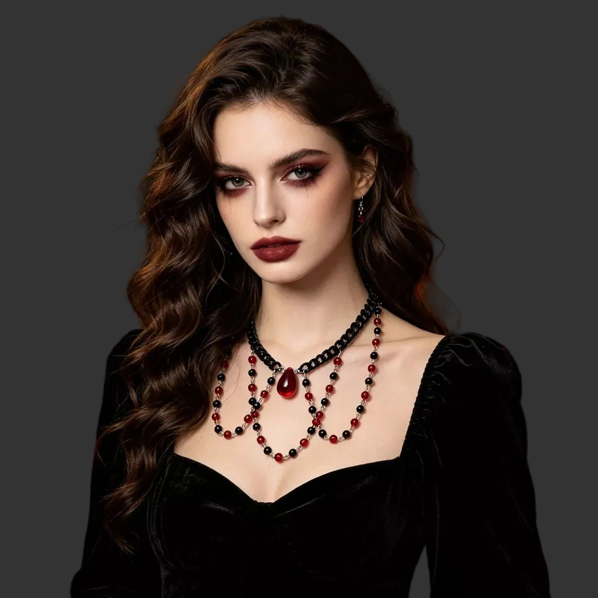 Red and black beaded choker with a red teardrop pendant worn with a black velvet dress