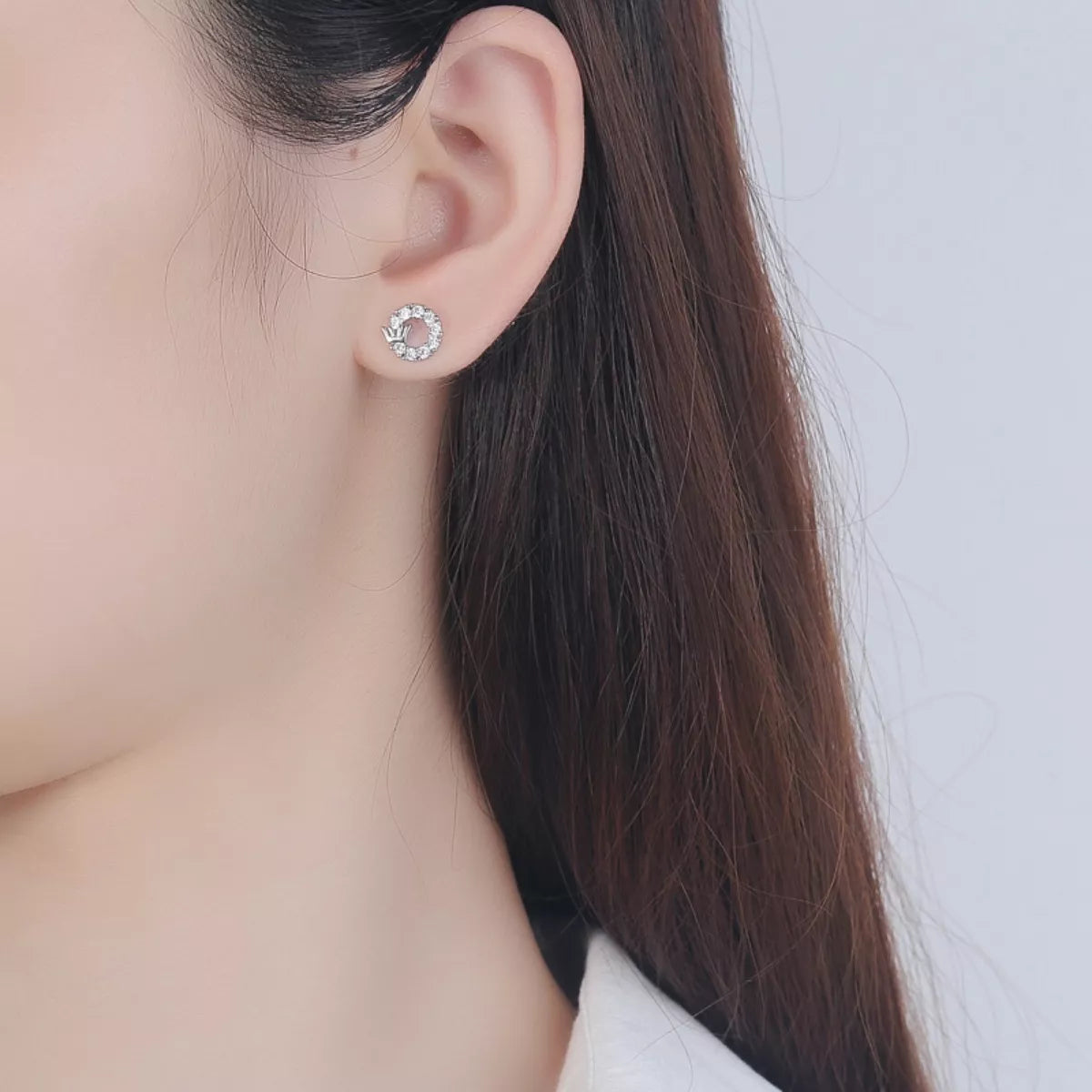 close up Model wearing Rebellious Gal crown circle stud earrings with rebellious layered ear stack