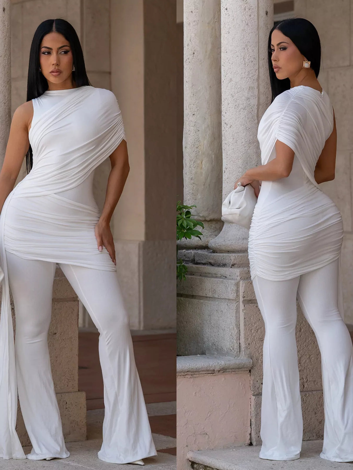 Woman wearing a white outfit with a draped design in an outdoor setting.