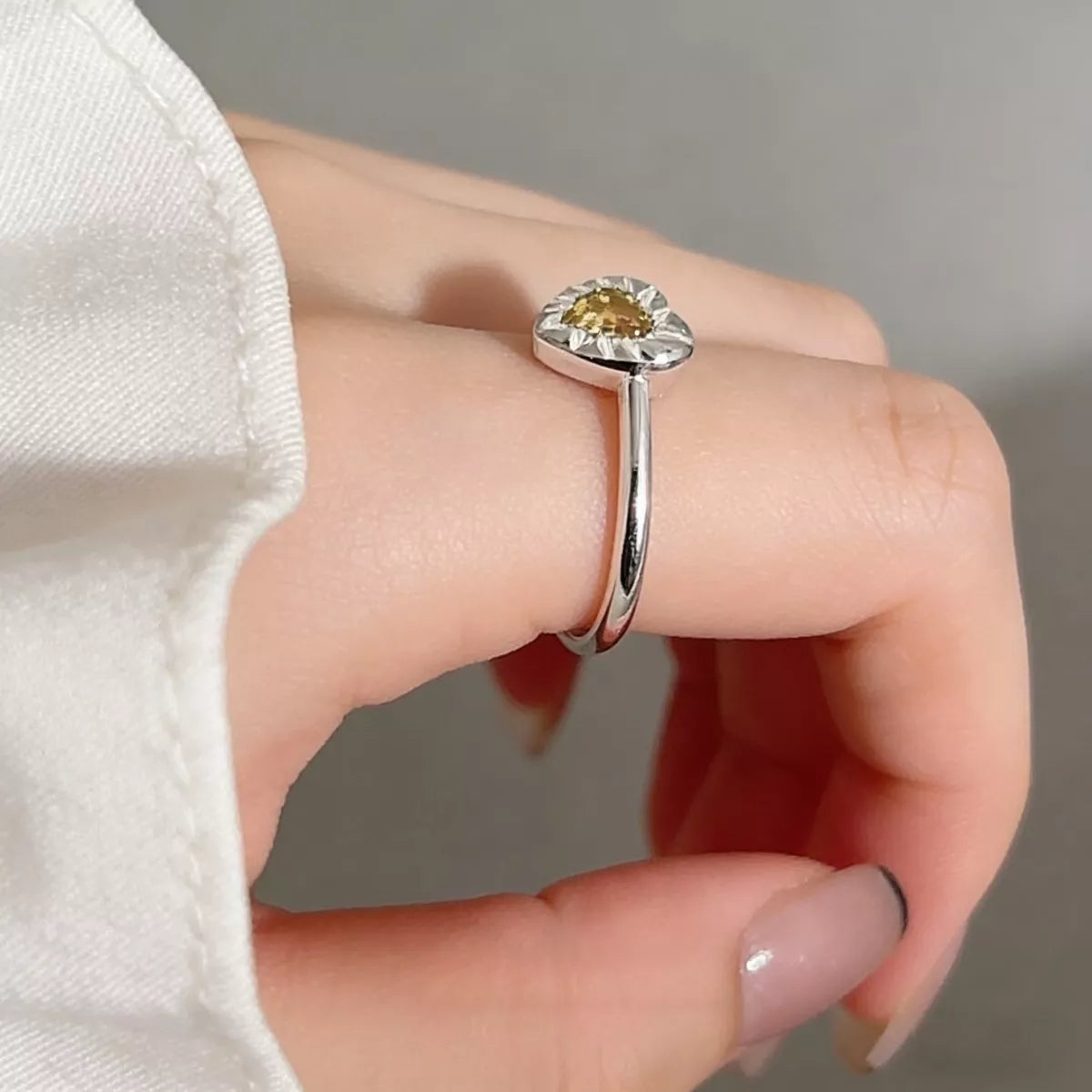 On-model finger shot showing how the heart-shaped ring sits elegantly