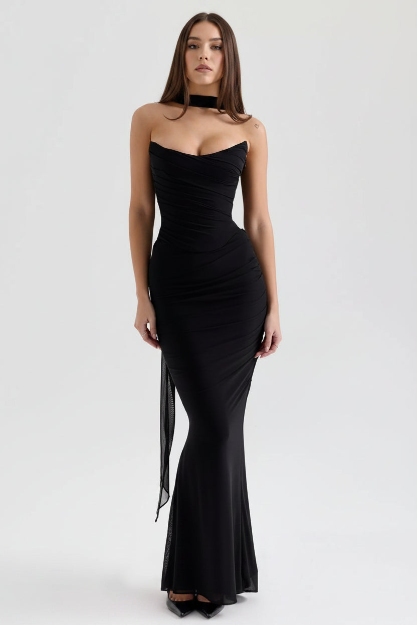 Black strapless gown with a slit on a white background