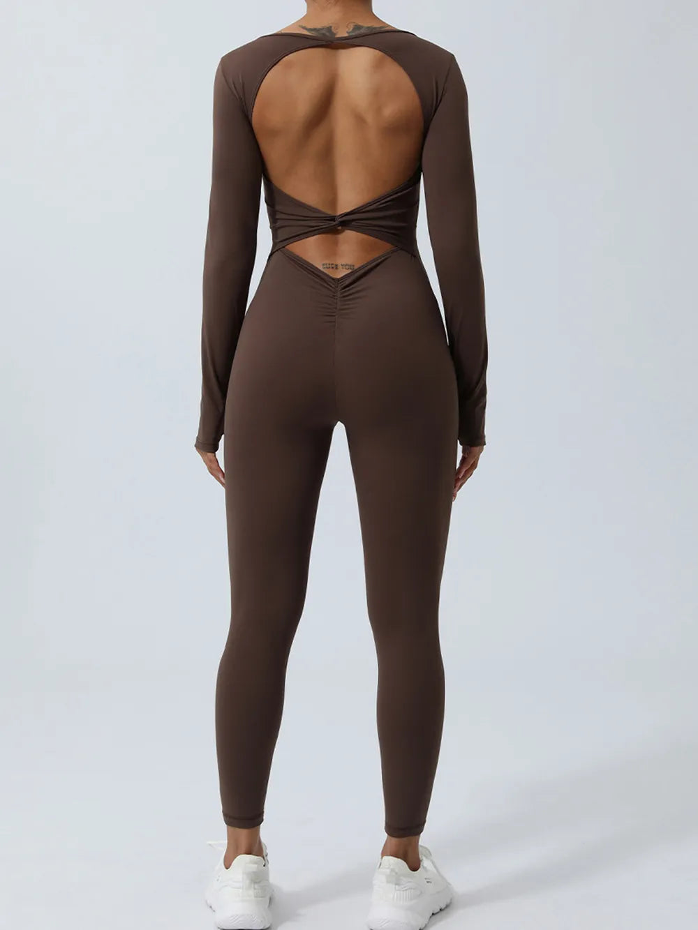 Brown jumpsuit from the back, edges crossing once below the opening, ruched seam down the seat