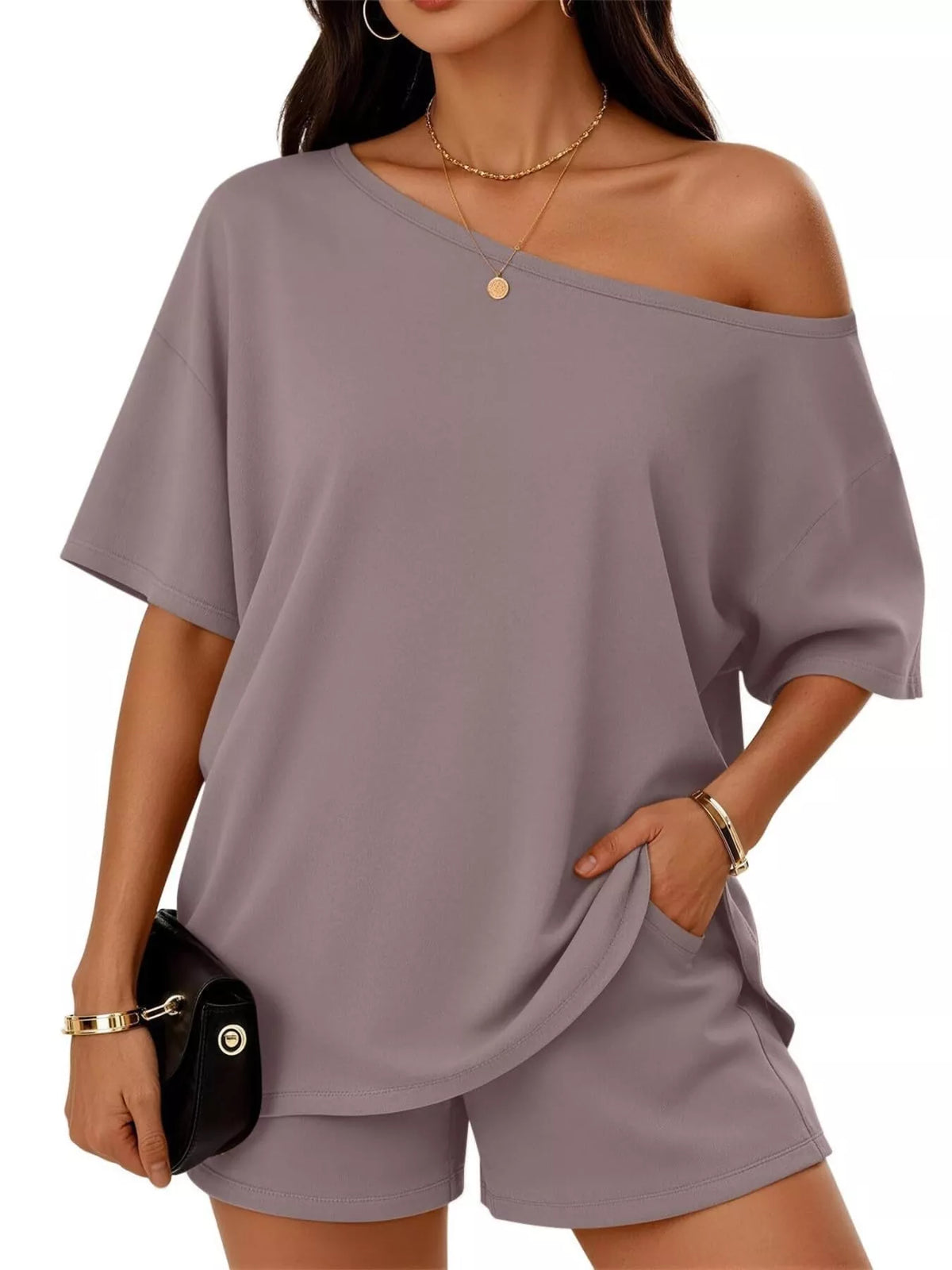 Woman wearing a gray off-shoulder top and shorts set on a white background