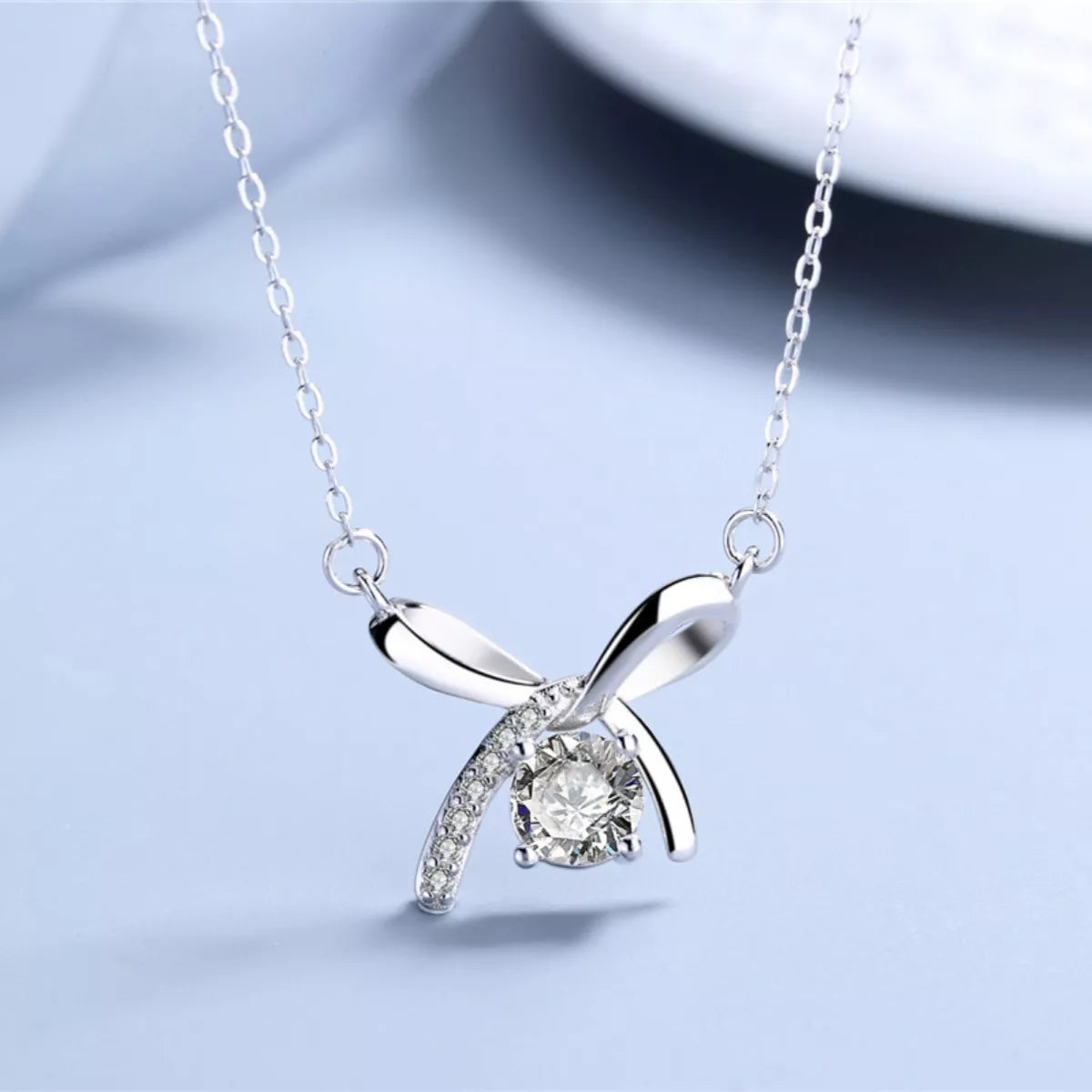 Close-up texture of polished platinum-plated finish and delicate ribbon details