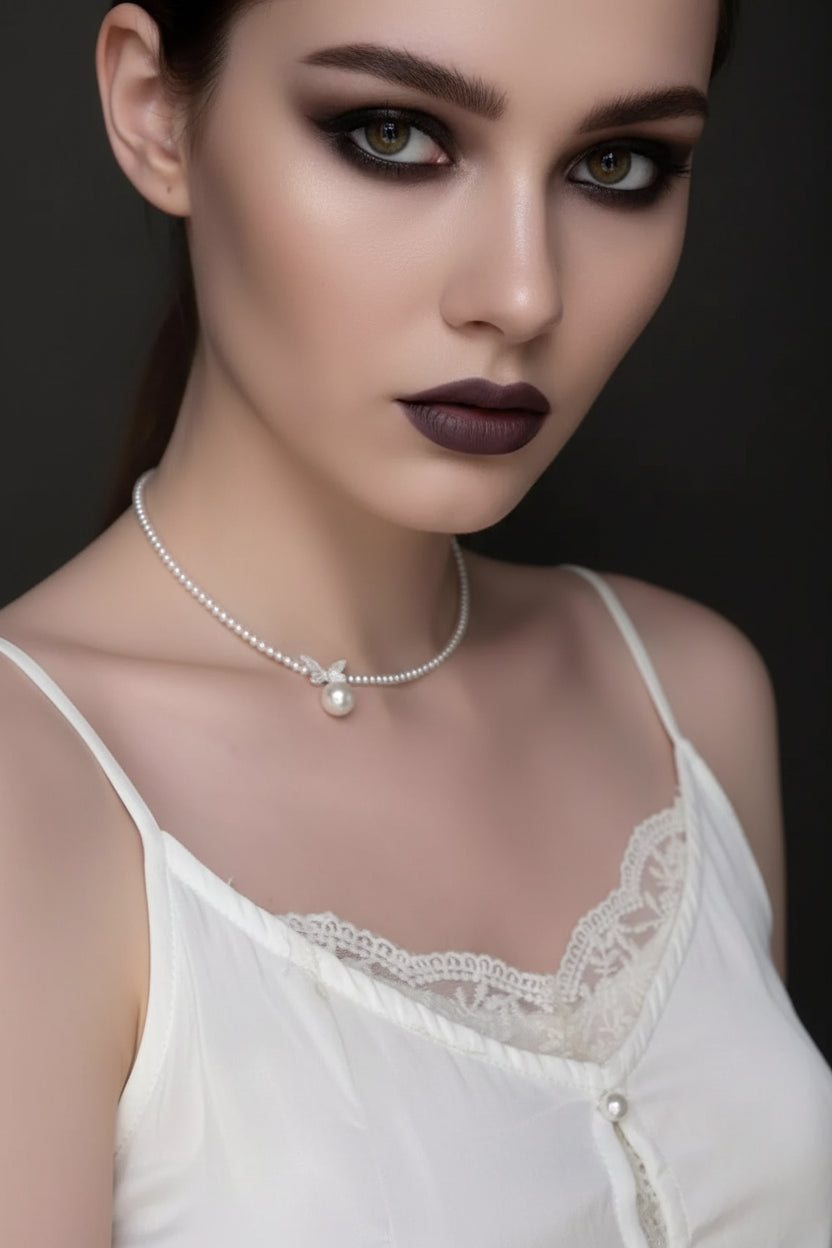 Pearl necklace with a pendant on a model wearing a white lace top.