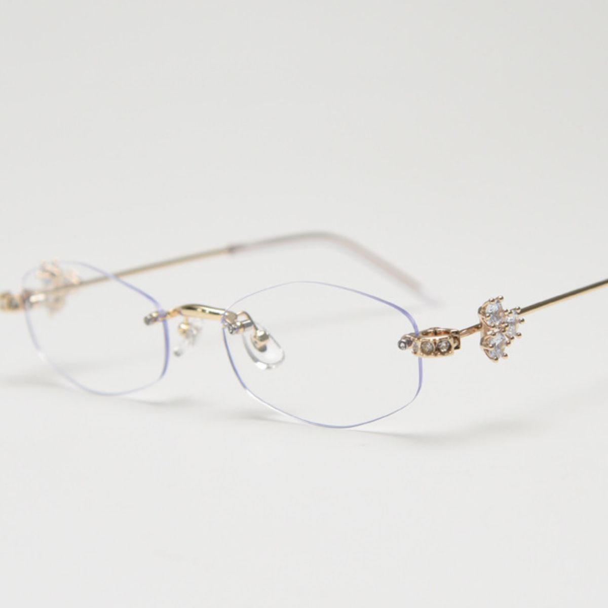 Close-up of delicate metal rimless frames with subtle resin accent details