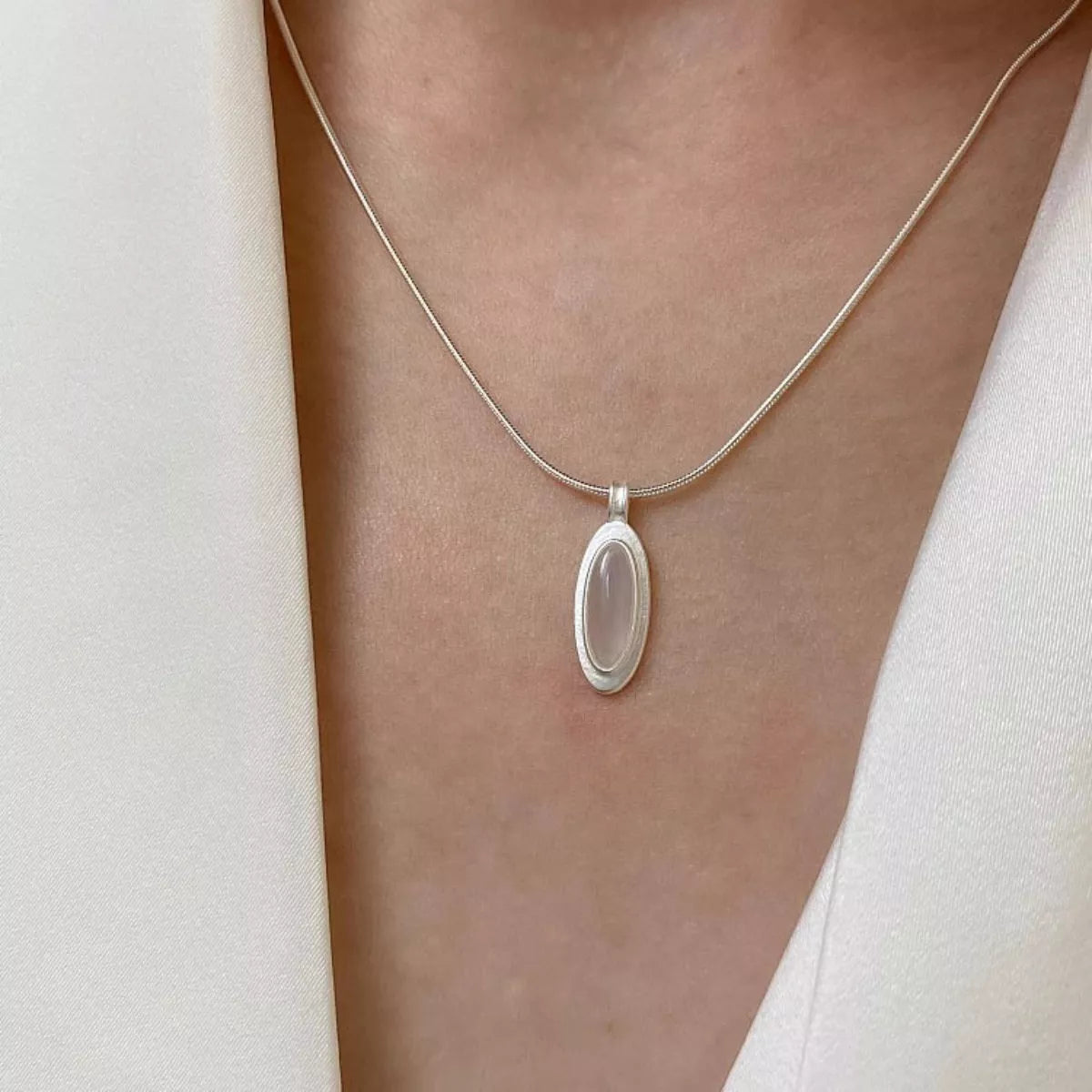 Geometric agate pendant styled with other silver pieces for rebellious stack