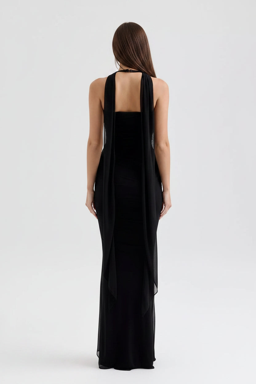 Black evening gown with a sheer overlay on a white background