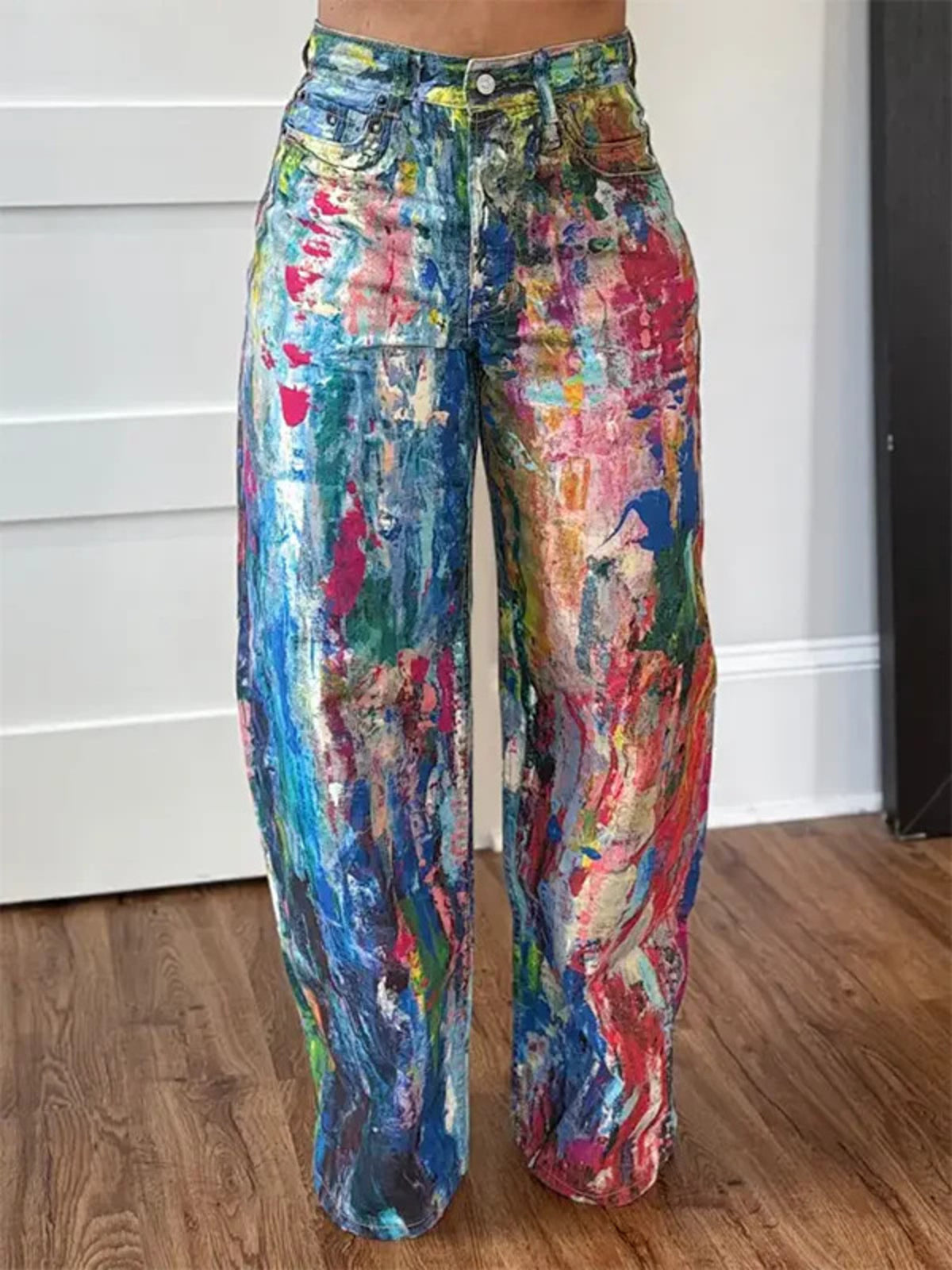 Colorful abstract-patterned pants on a wooden floor.