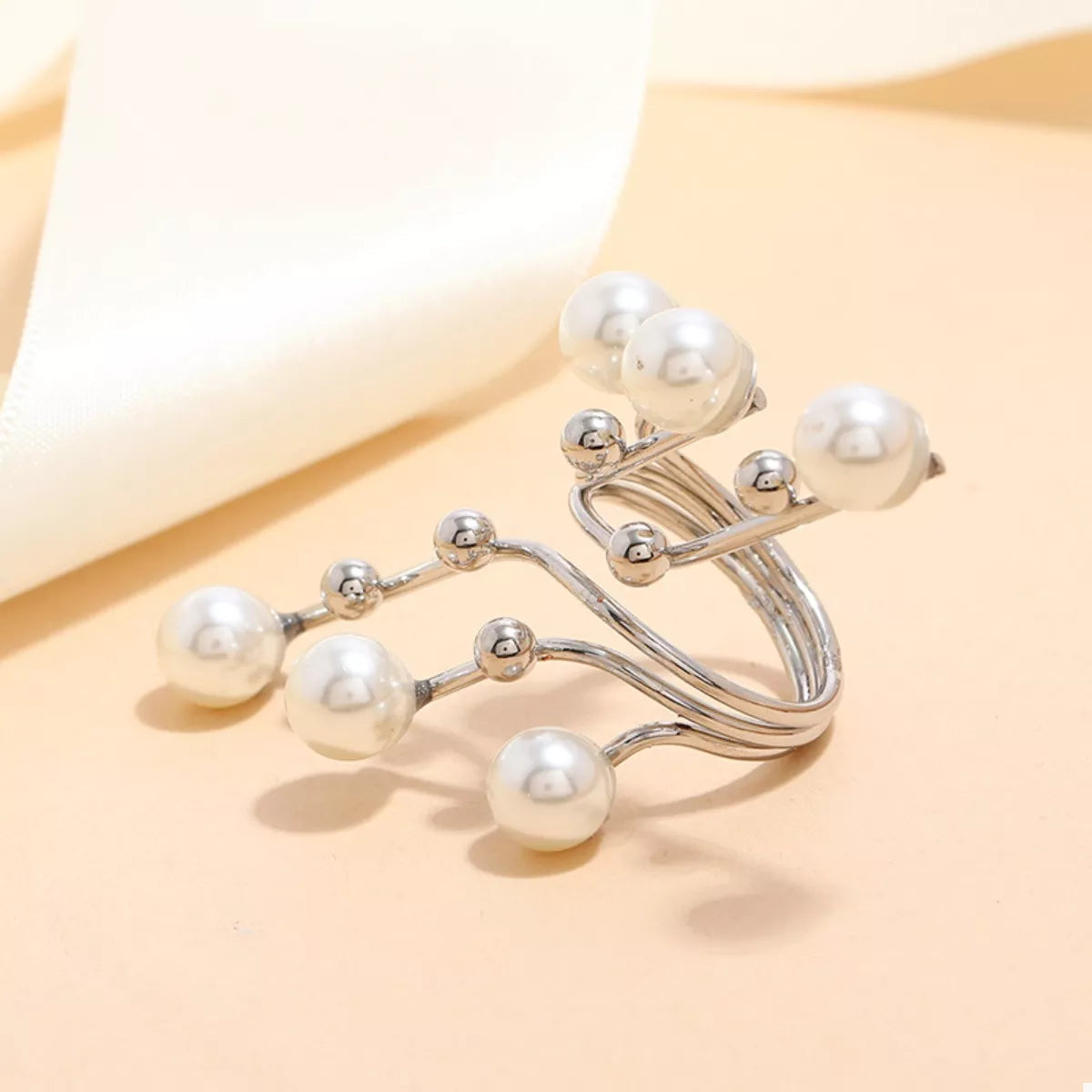 Silver bracelet with pearls on a beige background