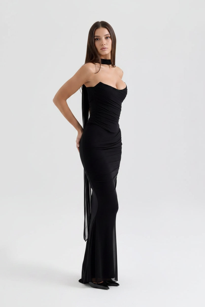 Black strapless gown with sheer side panels on a white background