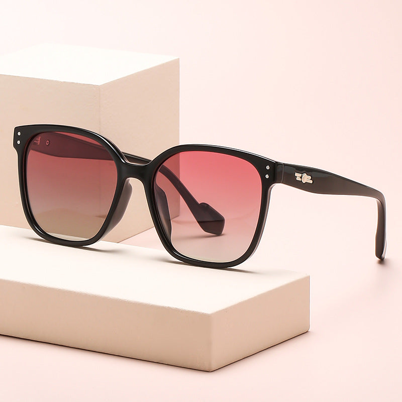 Oversized gradient lens sunglasses in bold black frame on rebellious woman