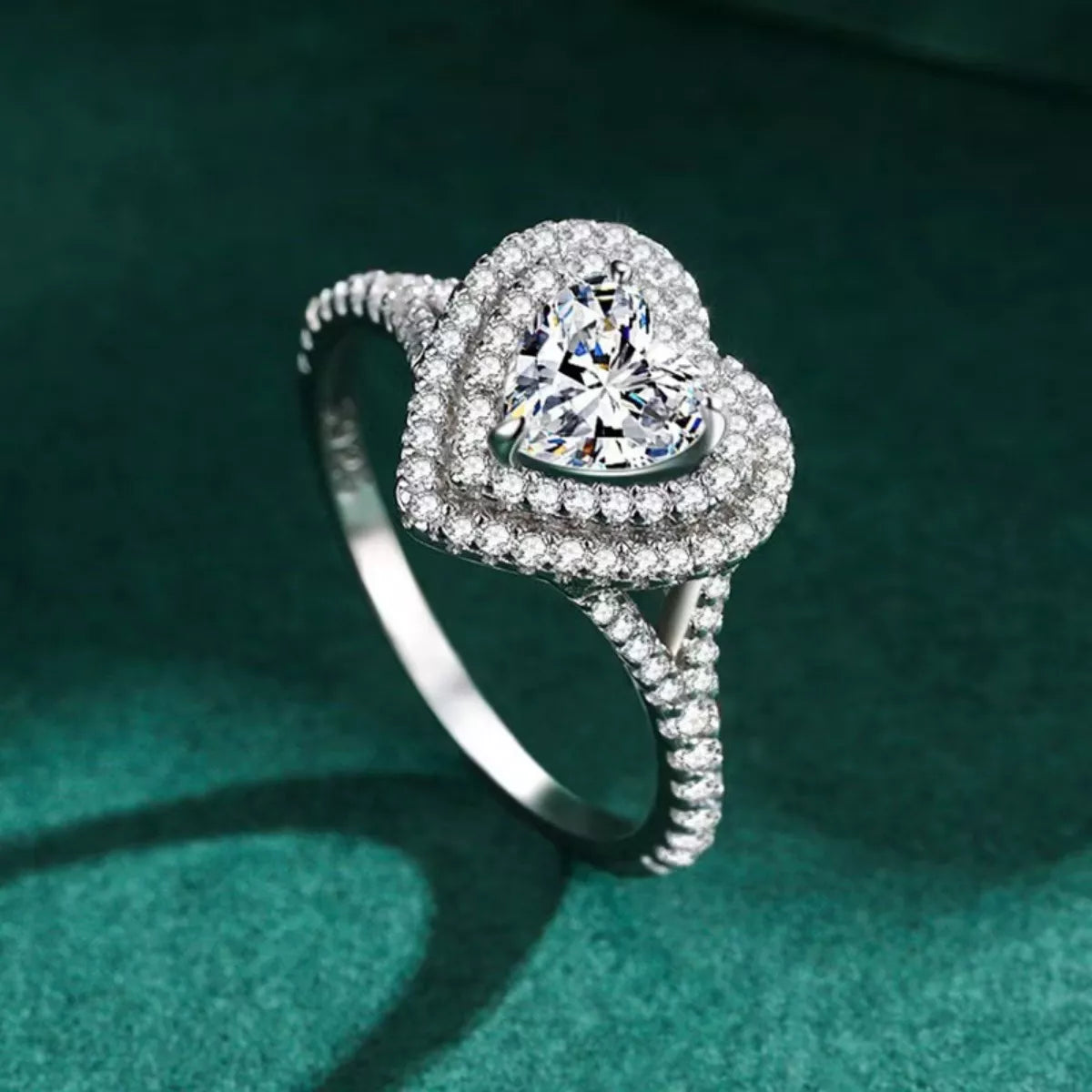 Close-up heart shaped diamond ring with green background