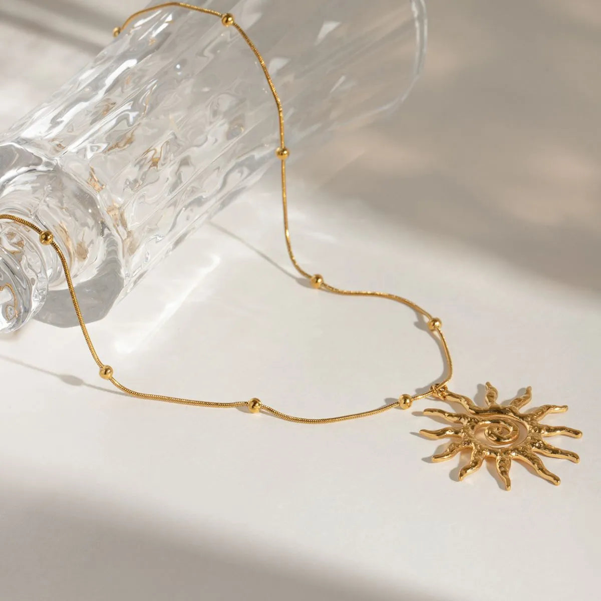sun pendant on a glass and white background neutral tone