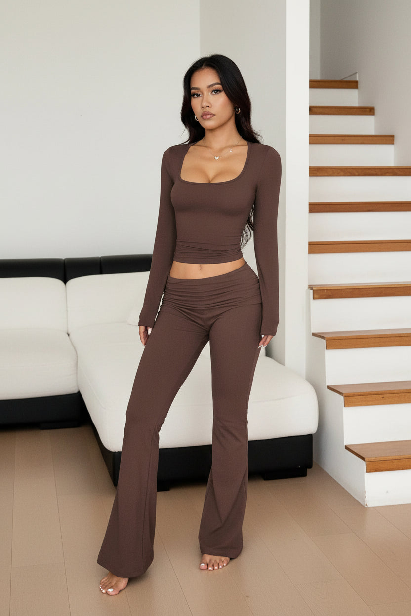 Woman wearing a brown long-sleeve top and leggings set indoors.