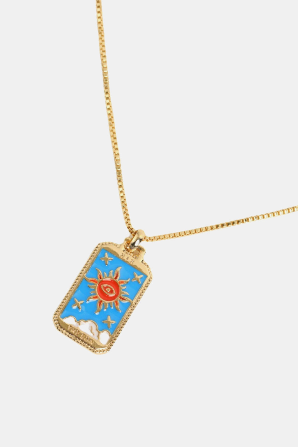 Gold necklace with a blue pendant featuring a sun design on a white background