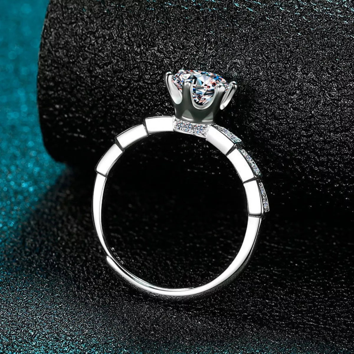 Silver ring with a large diamond on a dark textured background