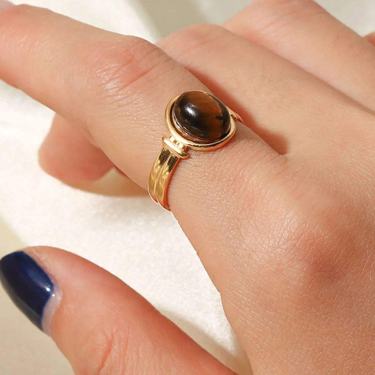 Natural stone tiger's eye adjustable ring 18K gold plated on finger neutral background