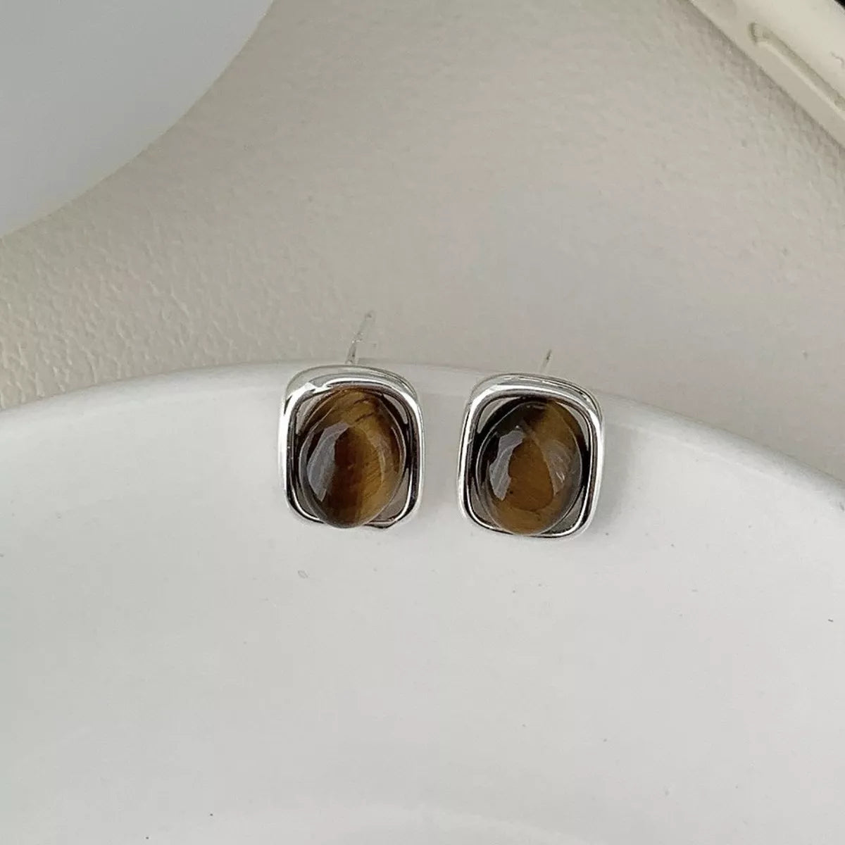 Rebellious Gal bold square tiger eye stud earrings stacked with other jewelry on ear