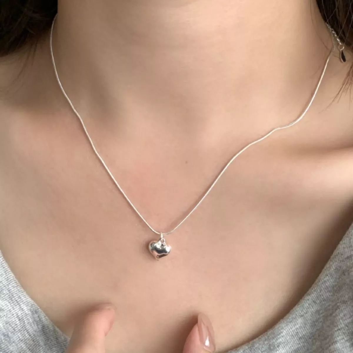 Heart necklace worn on model showing elegant simplicity