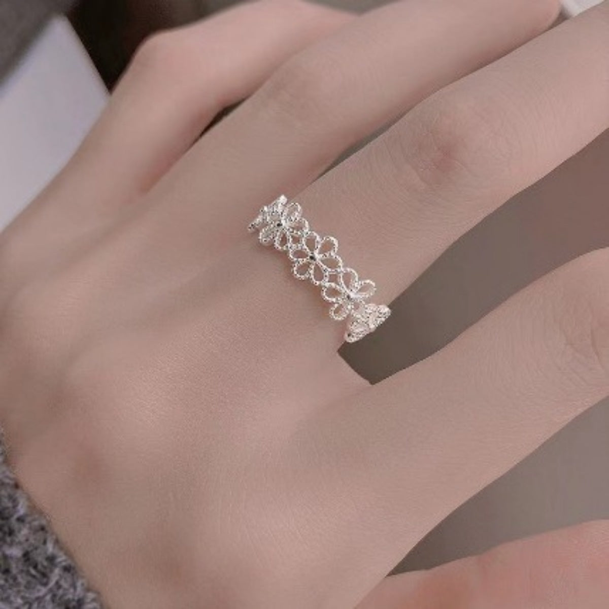 Model wearing Rebellious Gal floral open ring with rebellious layered jewelry