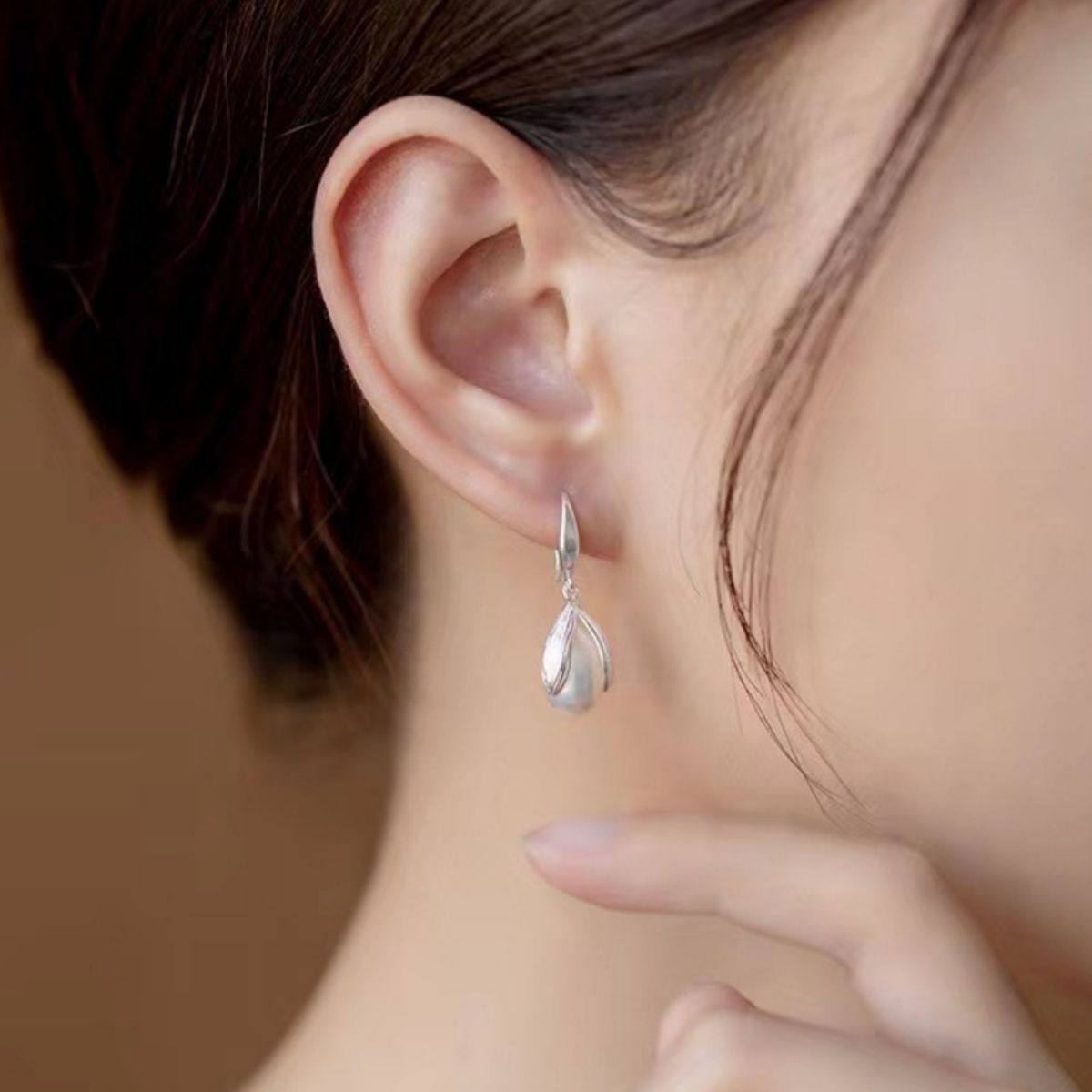 Model wearing Rebellious Gal synthetic pearl drop earrings with rebellious layered ear stack
